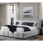 Modern upholstered gray bed in minimalist bedroom with black and white bedding and large windows