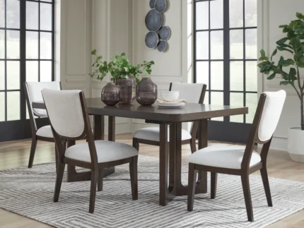 Modern dark wood dining table set with four upholstered cream chairs on a patterned area rug in a bright contemporary dining room